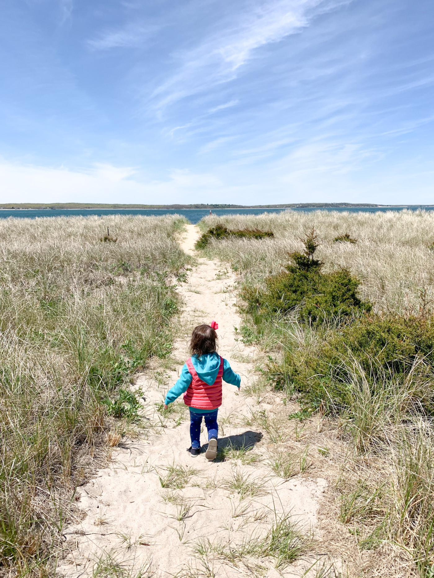 girl running in the sand in the hamptons